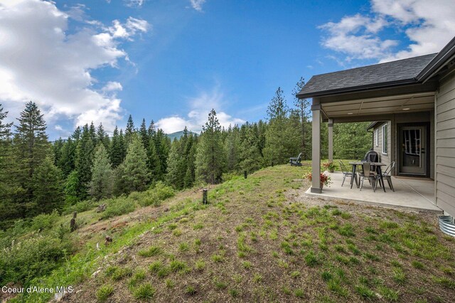 27968 N Timber Ridge Rd, Rathdrum, ID 83858 - view of yard featuring a patio area and a view of trees