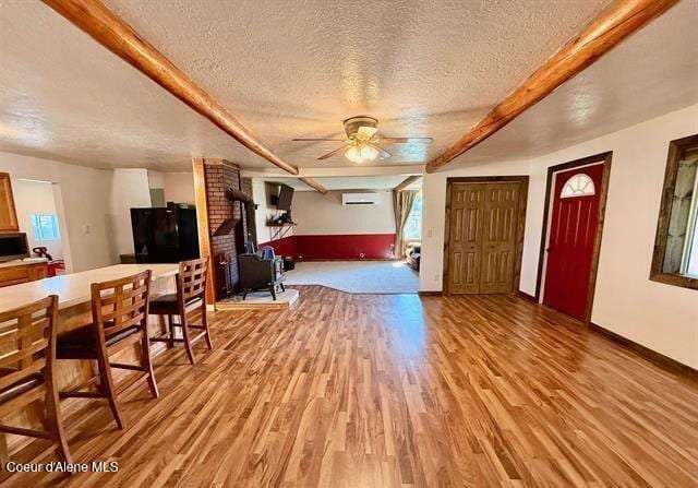 602 Spalding Ave, Winchester, ID 83555 - entrance foyer with a textured ceiling, an AC wall unit, light wood-style floors, ceiling fan, and a wood stove