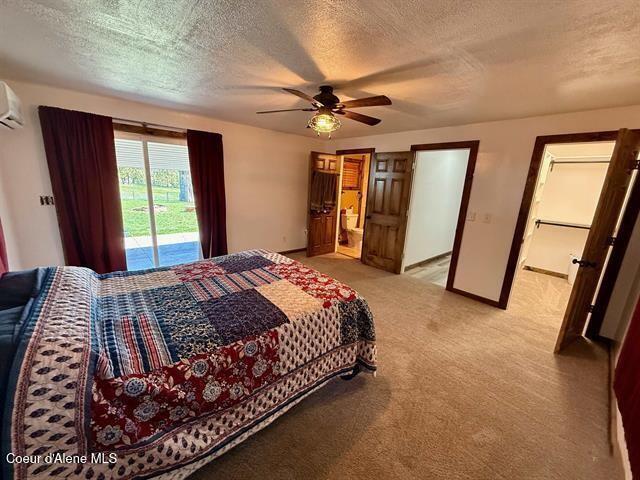 602 Spalding Ave, Winchester, ID 83555 - bedroom featuring access to outside, a textured ceiling, light colored carpet, an AC wall unit, and a ceiling fan
