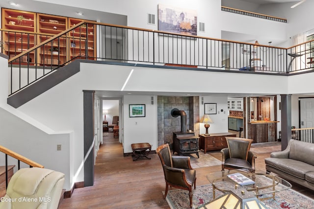 5005 W Cougar Estates Rd, Coeur Dalene, ID 83814 - living room featuring a high ceiling, wood finished floors, stairway, a wood stove, and baseboards