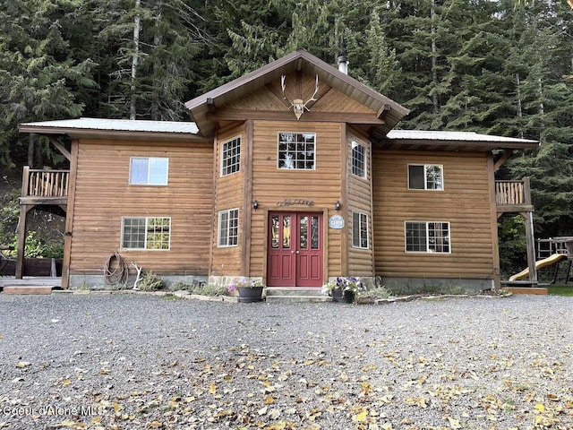 19118 St Joe River Rd, Calder, ID 83808 - rustic home with metal roof, a balcony, and a wooded view