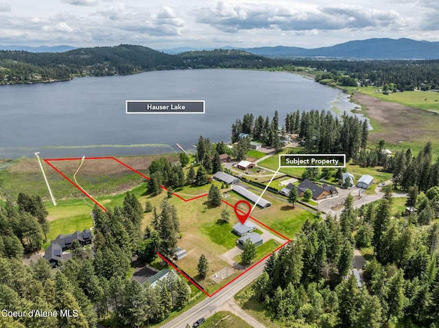 13744 N Hauser Lake Rd, Hauser, ID 83854 - aerial view of property and surrounding area featuring property parcel outlined, a water and mountain view, and a heavily wooded area
