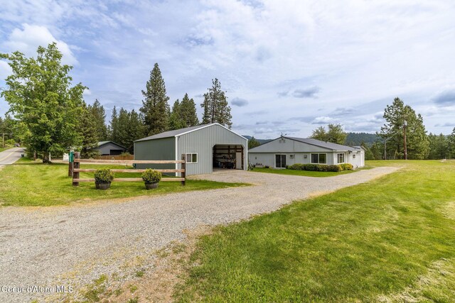 13744 N Hauser Lake Rd, Hauser, ID 83854 - view of front facade featuring an outbuilding, an outdoor structure, driveway, and a garage