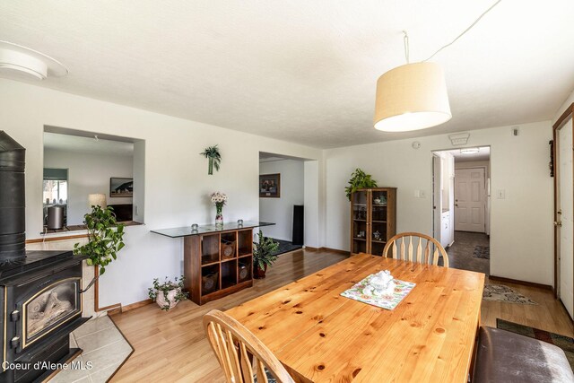 13744 N Hauser Lake Rd, Hauser, ID 83854 - dining area with wood finished floors, a wood stove, and baseboards