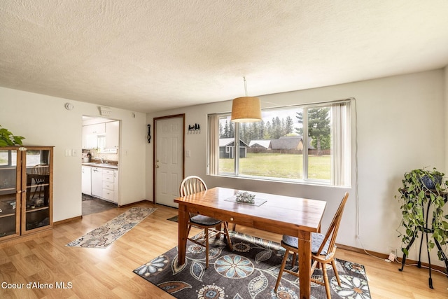 13744 N Hauser Lake Rd, Hauser, ID 83854 - dining area with light wood-style floors, a textured ceiling, and baseboards