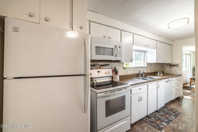 13744 N Hauser Lake Rd, Hauser, ID 83854 - kitchen featuring white appliances, a sink, backsplash, and white cabinetry