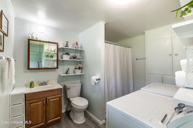 13744 N Hauser Lake Rd, Hauser, ID 83854 - full bath with washer and clothes dryer, wood finished floors, vanity, toilet, and a textured ceiling