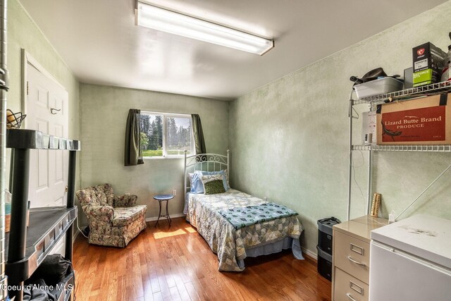 13744 N Hauser Lake Rd, Hauser, ID 83854 - bedroom with wood finished floors and refrigerator