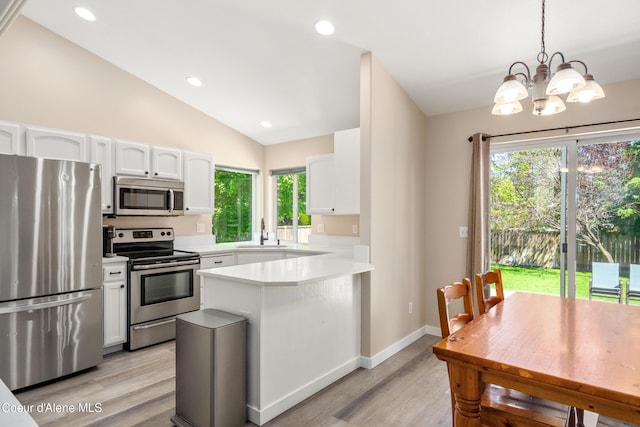 1800 N Willamette Dr, Post Falls, ID 83854 - kitchen with appliances with stainless steel finishes, a sink, light wood-type flooring, a peninsula, and light countertops