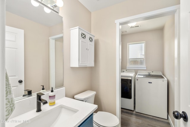 1800 N Willamette Dr, Post Falls, ID 83854 - bathroom featuring washer and clothes dryer, toilet, wood finished floors, and vanity