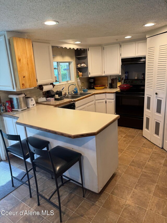 30625 Pastime St, Athol, ID 83801 - kitchen with black / electric stove, exhaust hood, a sink, a textured ceiling, and white cabinetry