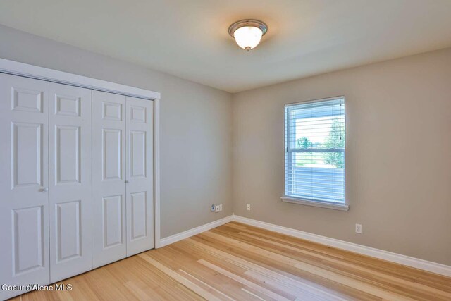 601 Mackies Way, Sandpoint, ID 83864 - unfurnished bedroom featuring baseboards, light wood-style floors, and a closet