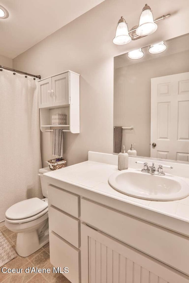 601 Mackies Way, Sandpoint, ID 83864 - bathroom with vanity, tile patterned flooring, toilet, and a shower with shower curtain