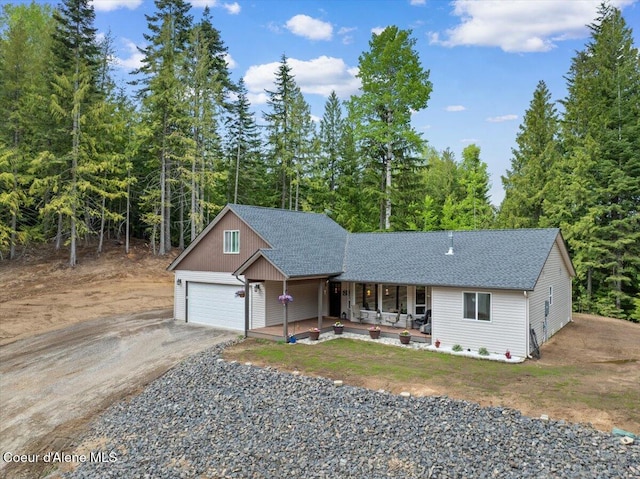 12671 E Trout Pond Rd, Athol, ID 83801 - ranch-style home featuring a porch, a shingled roof, asphalt driveway, and a garage
