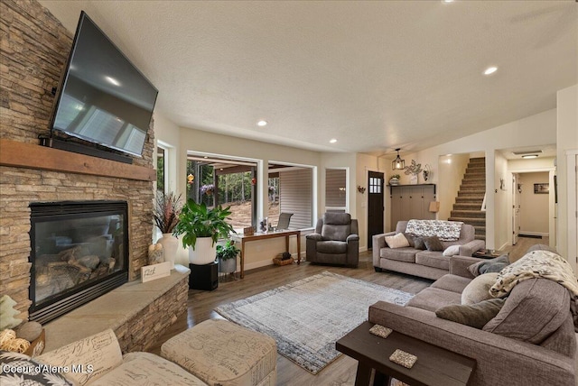 12671 E Trout Pond Rd, Athol, ID 83801 - living area with stairway, a stone fireplace, wood finished floors, recessed lighting, and baseboards
