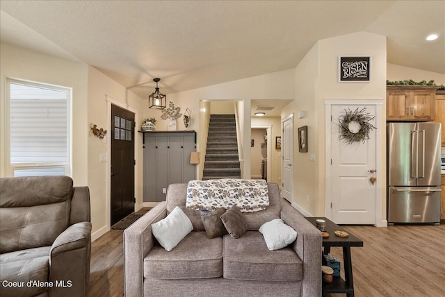 12671 E Trout Pond Rd, Athol, ID 83801 - living room featuring lofted ceiling, light wood-type flooring, stairway, and baseboards