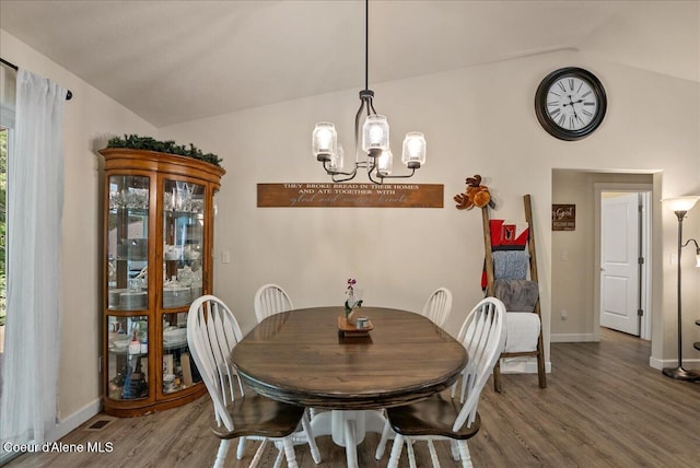12671 E Trout Pond Rd, Athol, ID 83801 - dining space with vaulted ceiling, wood finished floors, a chandelier, and baseboards