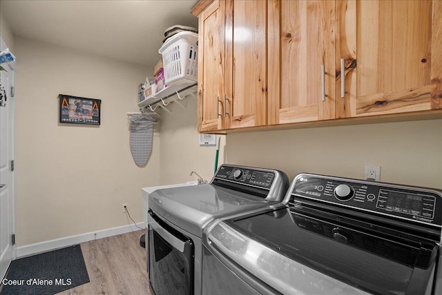 12671 E Trout Pond Rd, Athol, ID 83801 - washroom with independent washer and dryer, cabinet space, light wood-style flooring, and baseboards