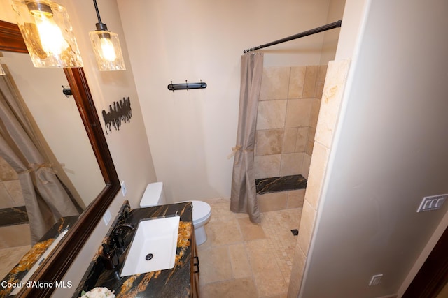 9057 W Benton Way, Coeur Dalene, ID 83814 - full bathroom with toilet, a tile shower, and vanity