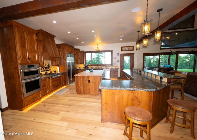 9057 W Benton Way, Coeur Dalene, ID 83814 - kitchen featuring stainless steel appliances, a spacious island, light wood finished floors, a breakfast bar area, and recessed lighting