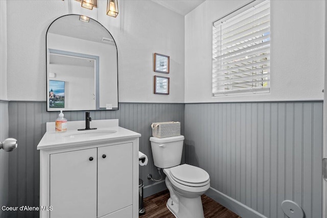 1482 N Skykomish Dr, Post Falls, ID 83854 - half bathroom featuring wainscoting, wood finished floors, vanity, and toilet