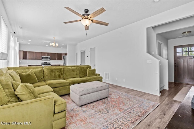 1482 N Skykomish Dr, Post Falls, ID 83854 - living area featuring a chandelier, a ceiling fan, wood finished floors, baseboards, and recessed lighting