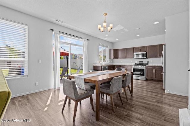 1482 N Skykomish Dr, Post Falls, ID 83854 - dining area with a chandelier, dark wood-style flooring, a textured ceiling, recessed lighting, and baseboards