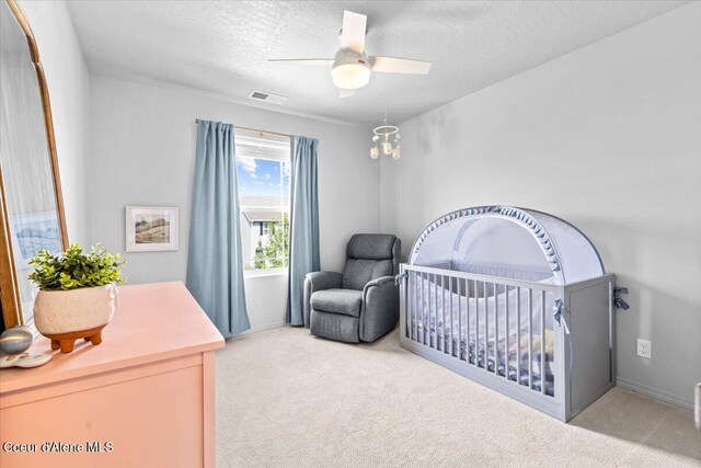 1482 N Skykomish Dr, Post Falls, ID 83854 - carpeted bedroom with a nursery area, a textured ceiling, and ceiling fan