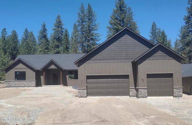 35 Parkland Ct, Blanchard, ID 83804 - view of front of house with stone siding, a garage, dirt driveway, and board and batten siding