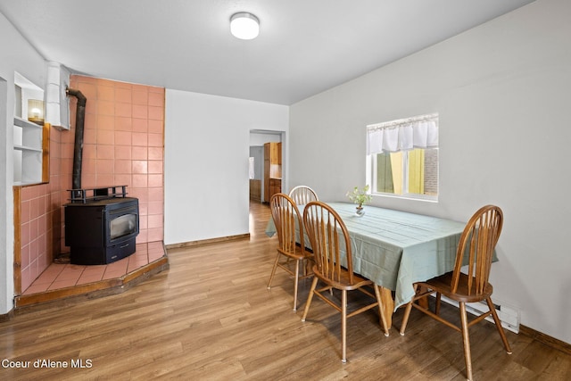 5739 W Maine St, Spirit Lake, ID 83869 - dining room featuring a wood stove, wood finished floors, and baseboards