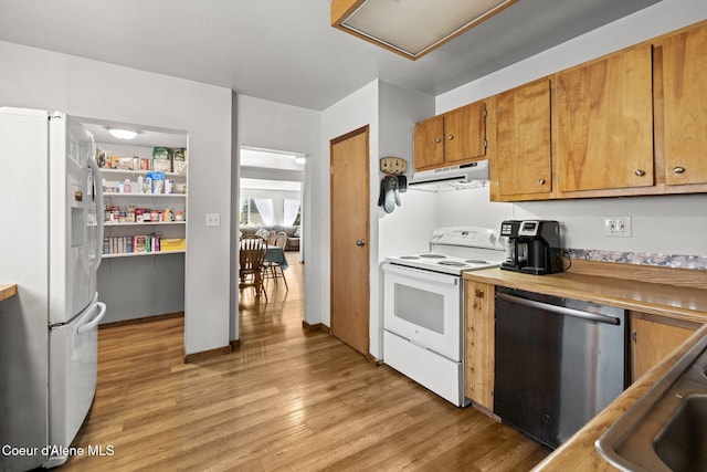 5739 W Maine St, Spirit Lake, ID 83869 - kitchen with white appliances, light wood-style flooring, under cabinet range hood, brown cabinets, and a sink