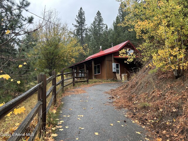 537 Pine St, Mullan, ID 83846 - view of side of property with driveway, metal roof, and a forest view