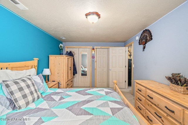 8558 N Boysenberry Loop, Hayden, ID 83835 - bedroom featuring two closets and a textured ceiling