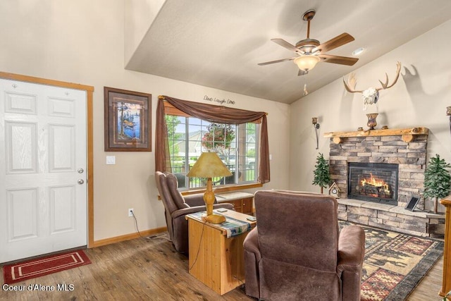8558 N Boysenberry Loop, Hayden, ID 83835 - living area featuring vaulted ceiling, wood finished floors, a stone fireplace, baseboards, and a ceiling fan