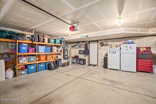 8558 N Boysenberry Loop, Hayden, ID 83835 - garage featuring freestanding refrigerator and a garage door opener