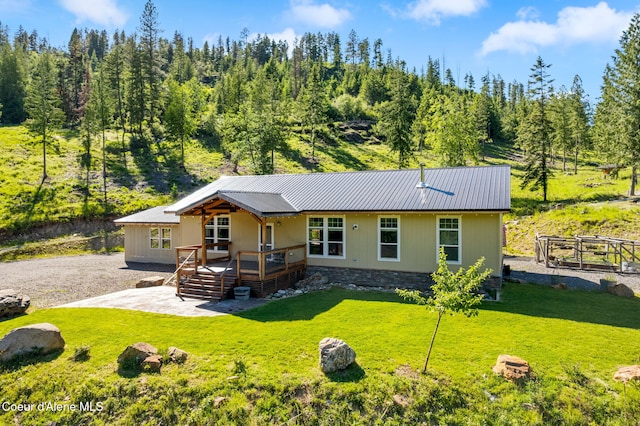 1446 Sagle Creek Rd, Sagle, ID 83860 - view of front of property featuring a front lawn, metal roof, a wooden deck, and a patio