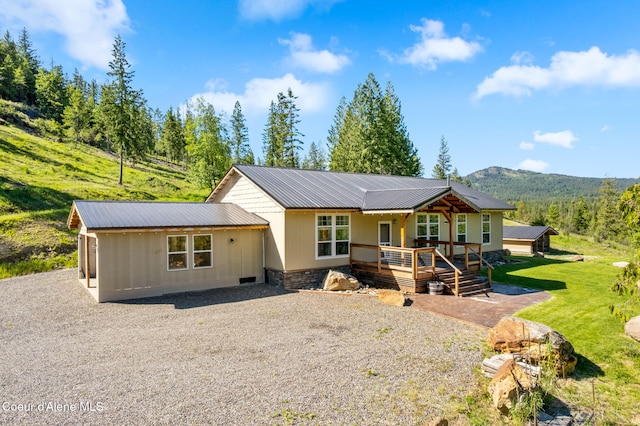 1446 Sagle Creek Rd, Sagle, ID 83860 - view of front of home with metal roof, gravel driveway, a front lawn, and a deck