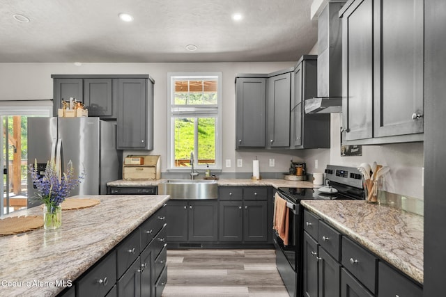 1446 Sagle Creek Rd, Sagle, ID 83860 - kitchen featuring electric stove, a sink, wall chimney exhaust hood, stainless steel refrigerator with ice dispenser, and light wood-type flooring
