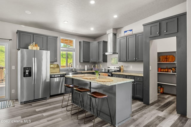 1446 Sagle Creek Rd, Sagle, ID 83860 - kitchen with stainless steel appliances, wall chimney range hood, a sink, light wood-style flooring, and recessed lighting