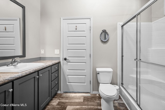 1446 Sagle Creek Rd, Sagle, ID 83860 - full bathroom featuring wood finished floors, toilet, vanity, and an enclosed shower