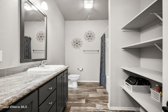 1446 Sagle Creek Rd, Sagle, ID 83860 - full bathroom with wood finished floors, vanity, toilet, shower / bath combo with shower curtain, and baseboards