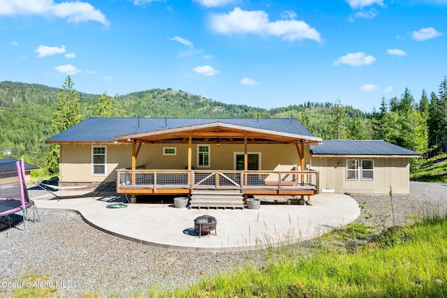 1446 Sagle Creek Rd, Sagle, ID 83860 - back of property with a fire pit, a patio, a wooden deck, and a wooded view