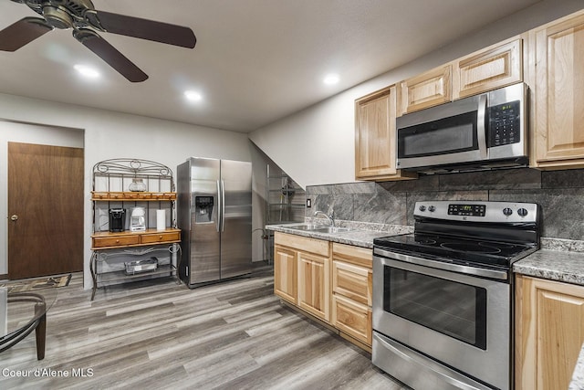 4684 E Wildlife Trl, Hayden, ID 83835 - kitchen with stainless steel appliances, light brown cabinets, a sink, ceiling fan, and decorative backsplash
