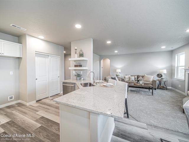 13668 N Apex Way, Hayden, ID 83835 - kitchen featuring a sink, dishwasher, arched walkways, open shelves, and white cabinets