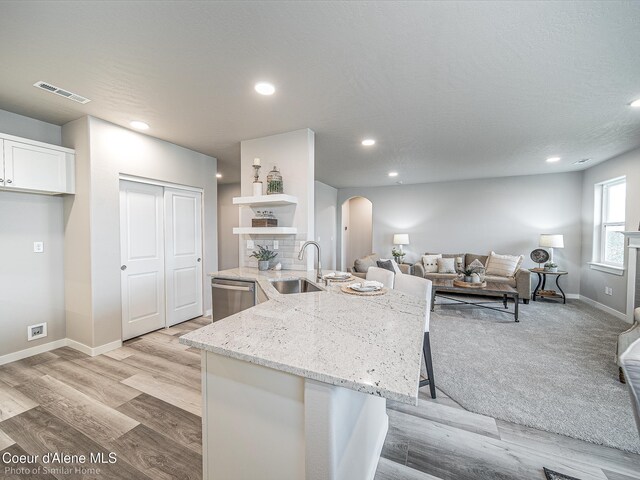 13668 N Apex Way, Hayden, ID 83835 - kitchen featuring a sink, dishwasher, arched walkways, open shelves, and white cabinets