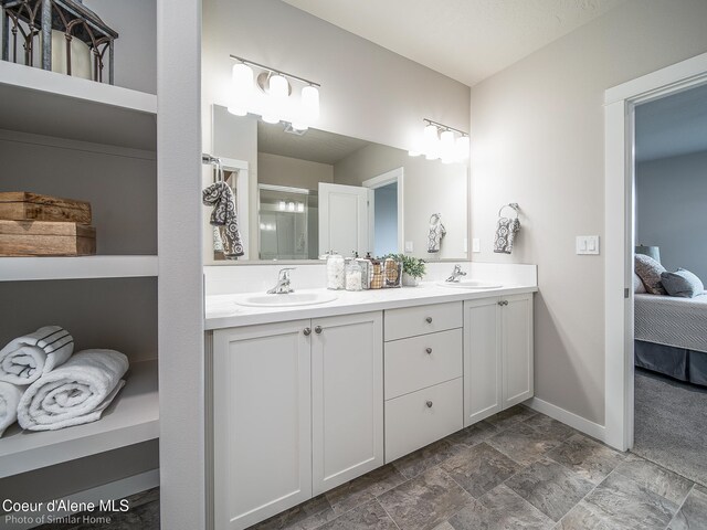 13668 N Apex Way, Hayden, ID 83835 - ensuite bathroom with double vanity, stone finish flooring, and baseboards