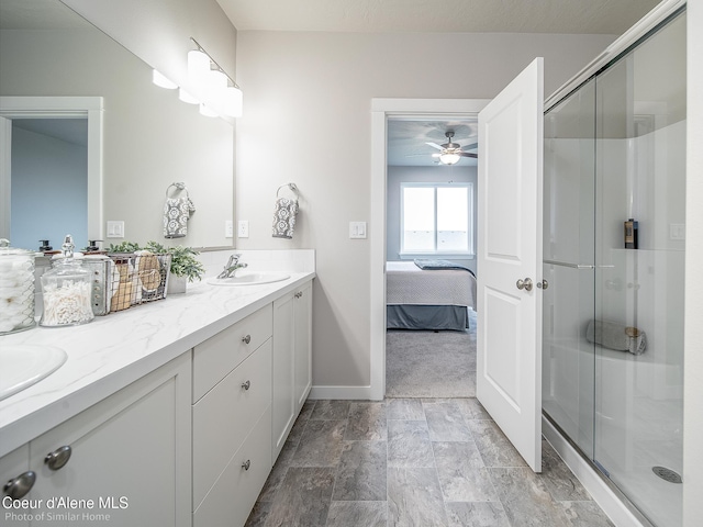 13668 N Apex Way, Hayden, ID 83835 - ensuite bathroom featuring double vanity, a stall shower, baseboards, and a ceiling fan