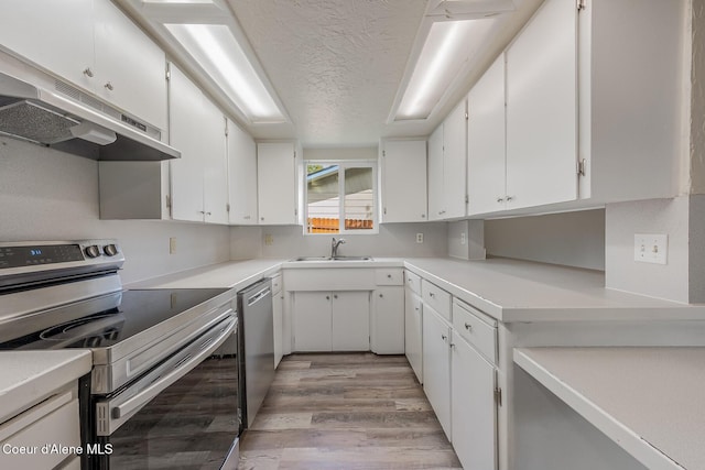 1611 E Birch St, Coeur Dalene, ID 83814 - kitchen with stainless steel appliances, under cabinet range hood, light wood-type flooring, a textured ceiling, and white cabinetry