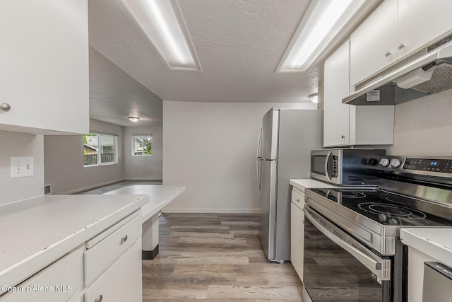 1611 E Birch St, Coeur Dalene, ID 83814 - kitchen featuring appliances with stainless steel finishes, under cabinet range hood, white cabinetry, light countertops, and a textured ceiling
