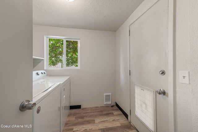 1611 E Birch St, Coeur Dalene, ID 83814 - washroom with washer and dryer, light wood finished floors, and a textured ceiling
